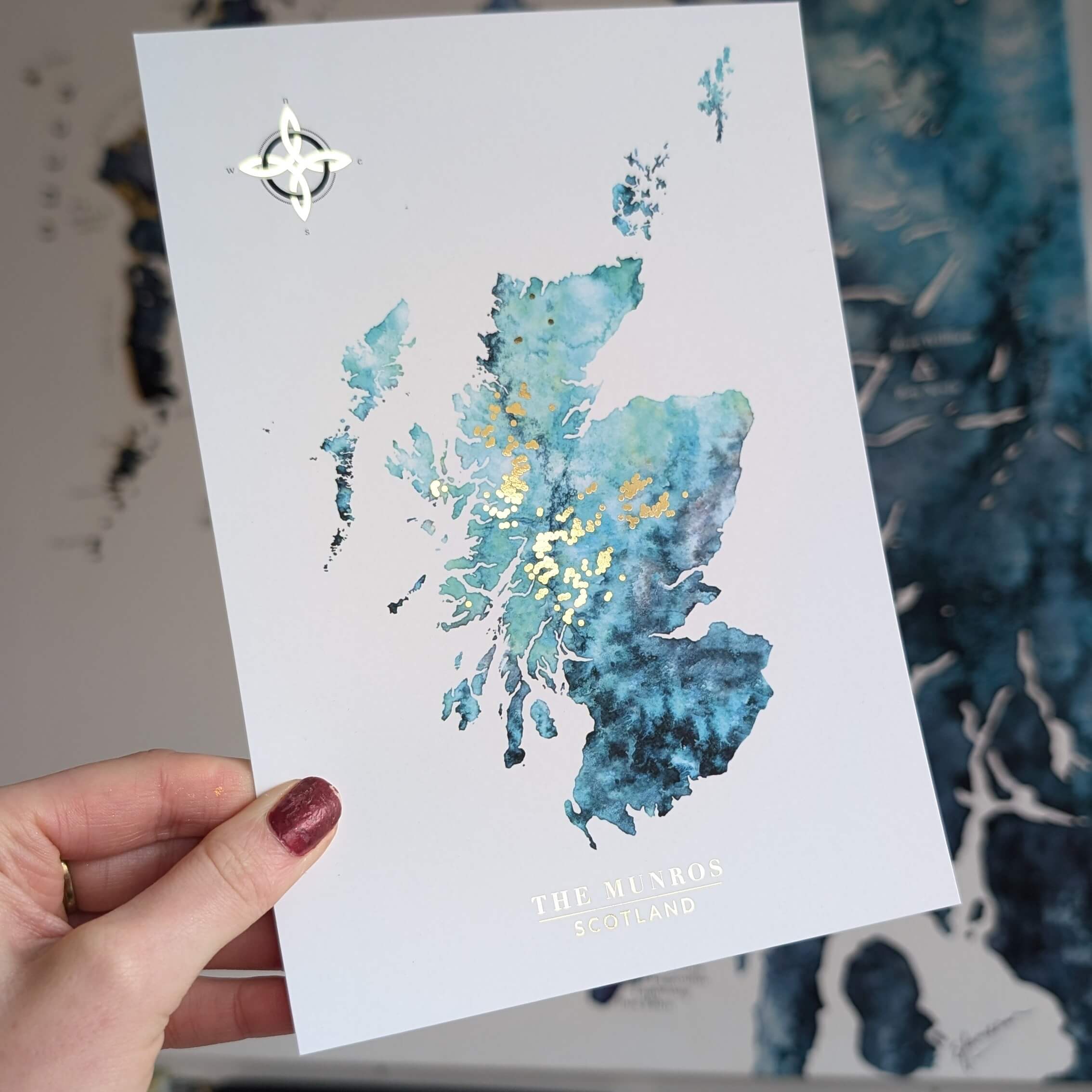 a blue watercolour map of Scotland with all the munro mountains in gold. perfect gift for a munro bagger