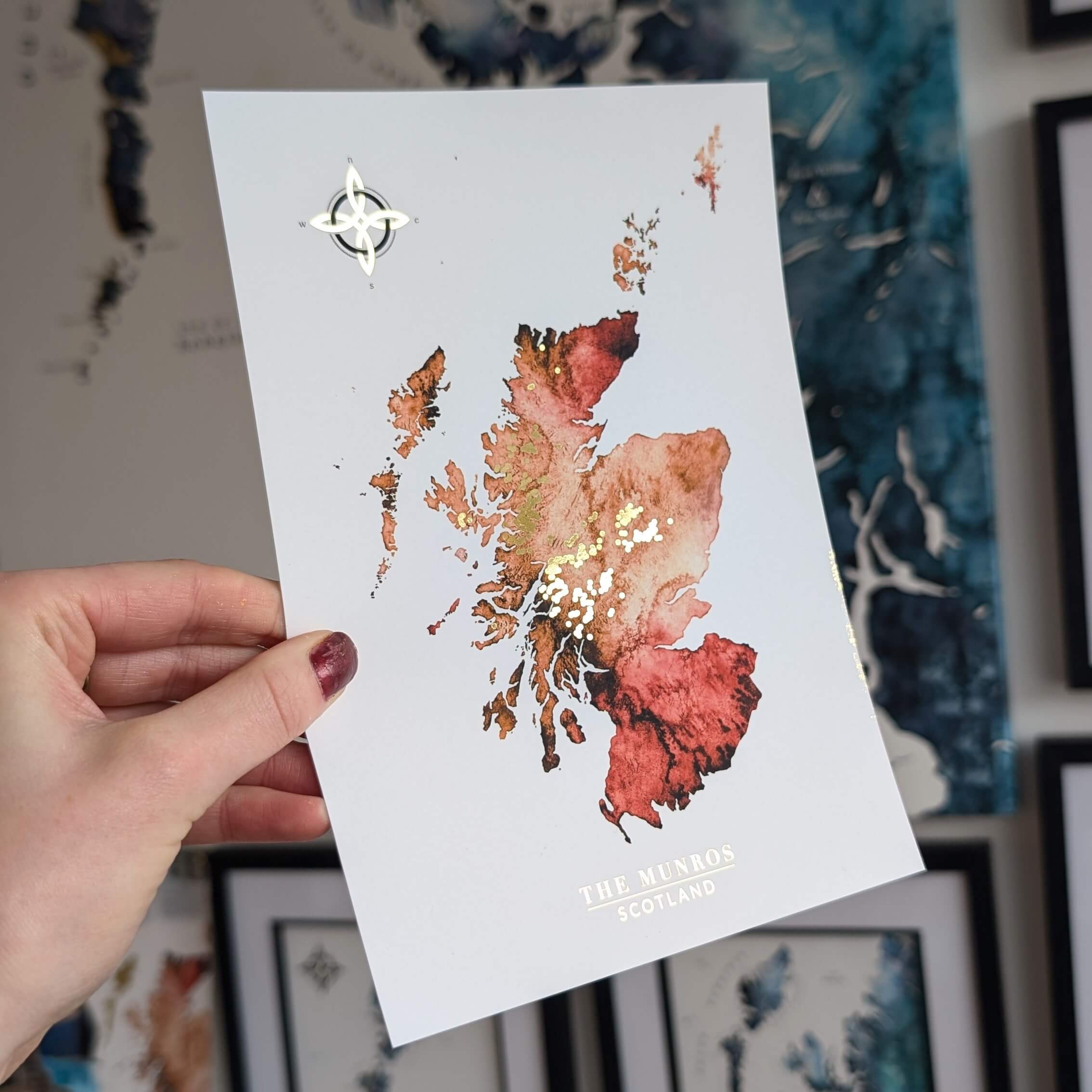 an orange watercolour map of Scotland with all the munro mountains in gold. perfect gift for a munro bagger