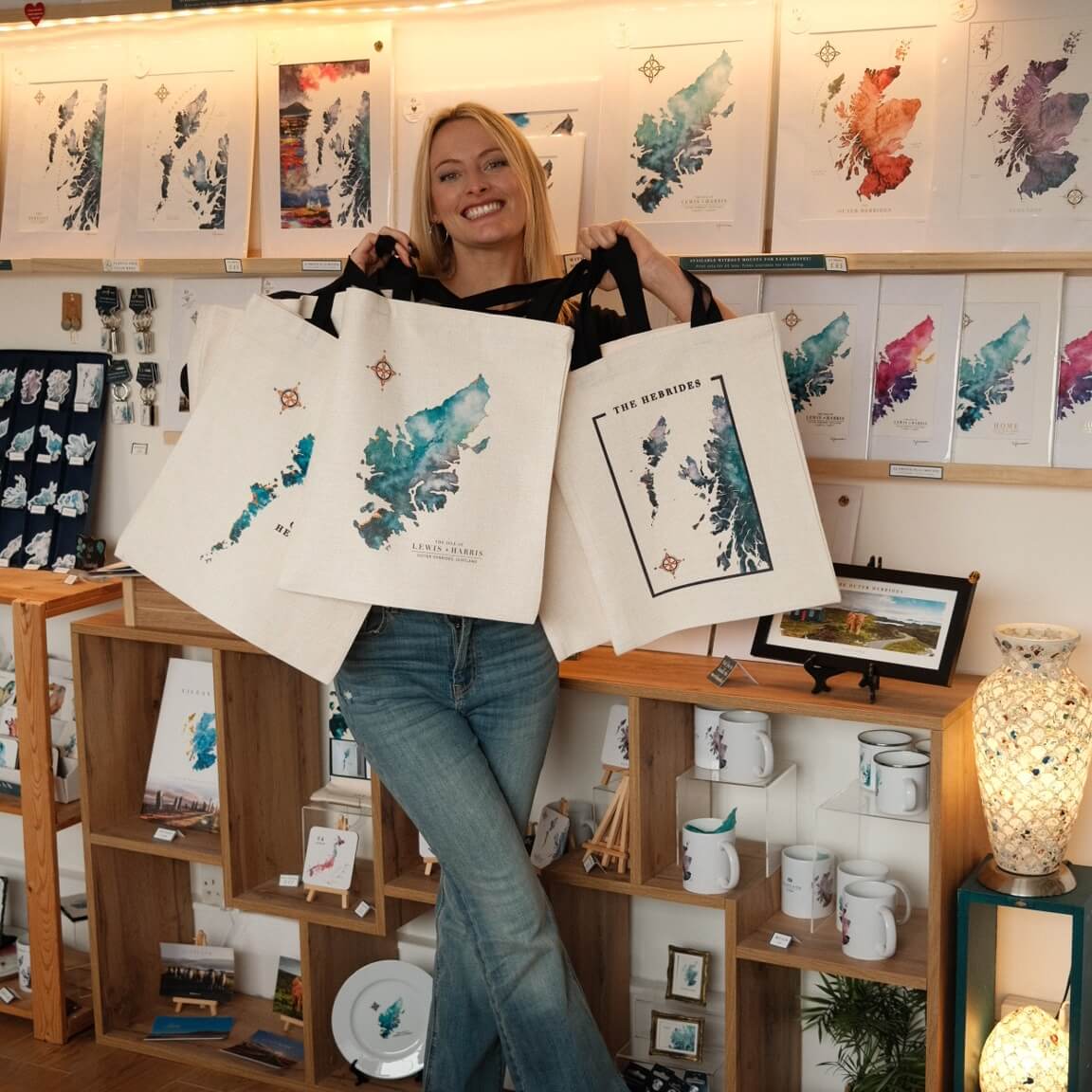 Hebridean Scottish artist Eilidh Jamieson holding her tote bag collection of watercolour maps